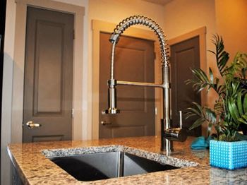 Modernized under-mounted stainless kitchen sinks with extendable gooseneck faucet at 4700 Colonnade apartment kitchens